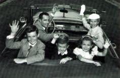 family waving from car